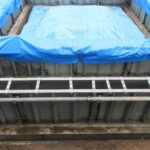 ブルーシートによる覆い状況の画像により生コンクリートの養生の重要性を象徴する1枚