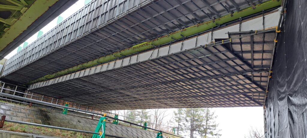 自身の実際の現場の全面吊り足場を下方から望んだ画像で足場仮設の良い例を示した