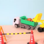 立入禁止措置のうえ、バックホウで土砂をダンプに積載している様子を親しみやすく玩具で表現した1枚